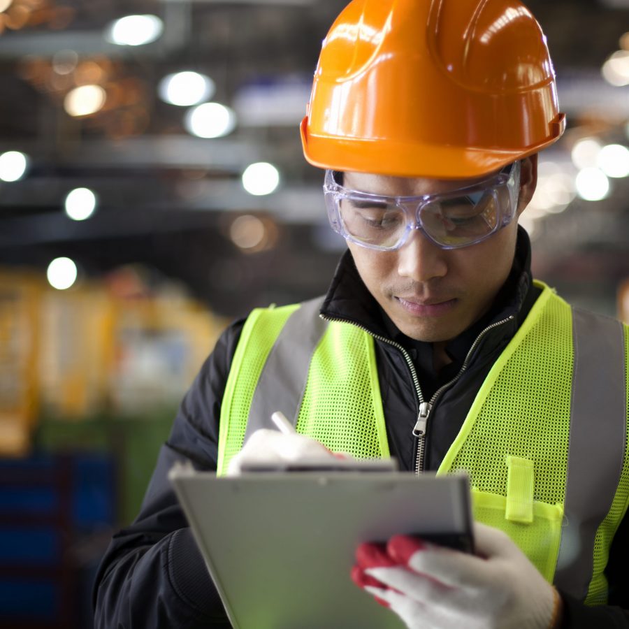 industrial engineer writing on notepad in factory